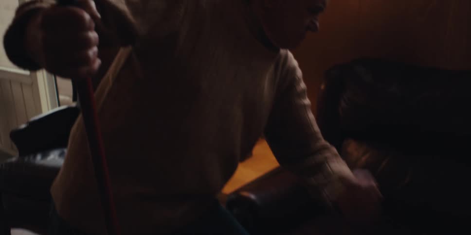 Elderly man having fun while cleaning the living room