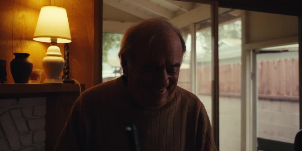 Elderly man in a room dancing while cleaning