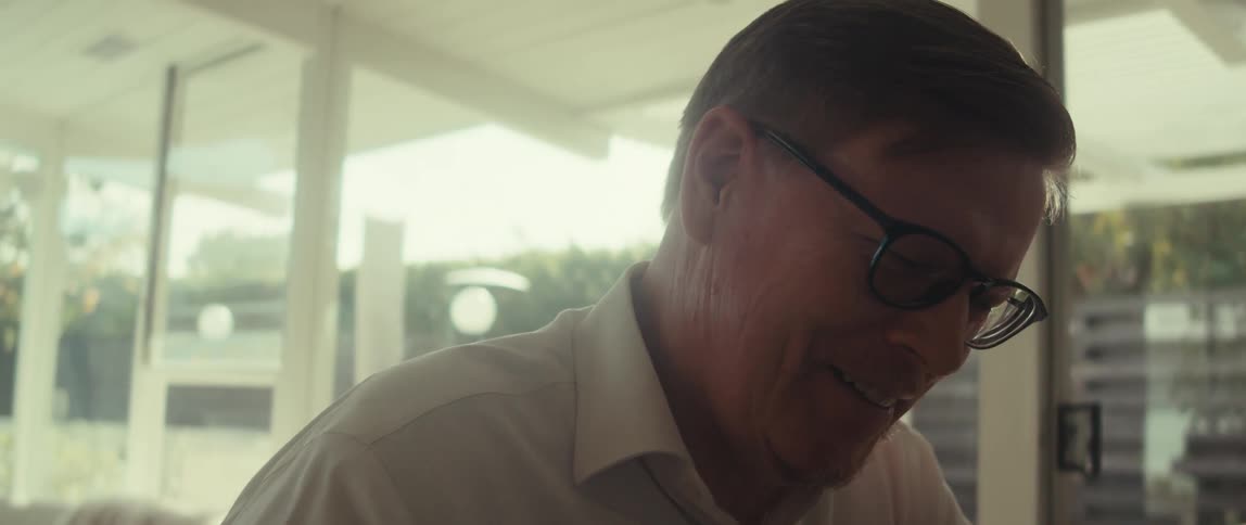 Man smiles while using his laptop in his home office