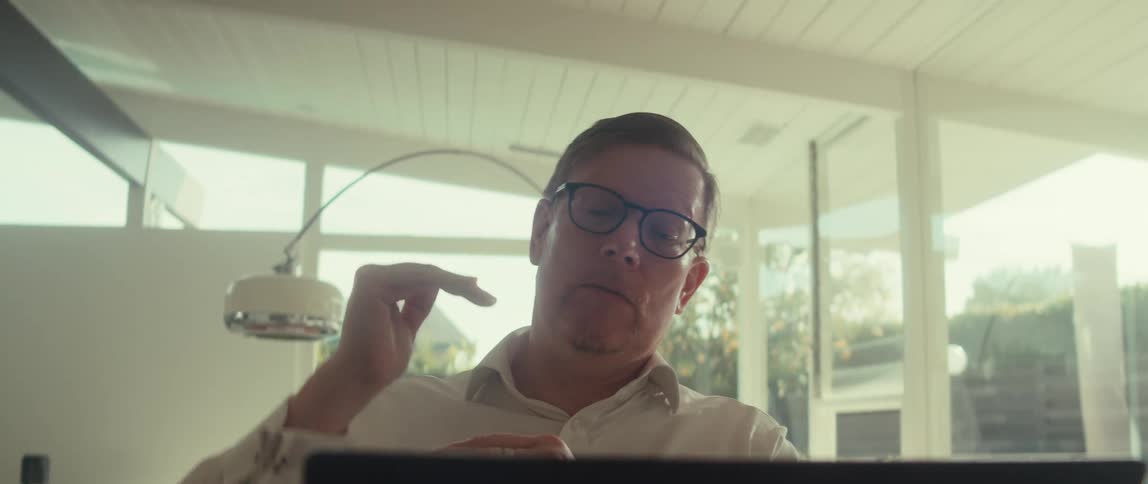 Man gestures during a video call while in his office