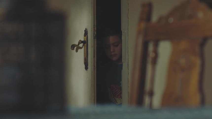 Two children opening a door and entering a room in the house carefully