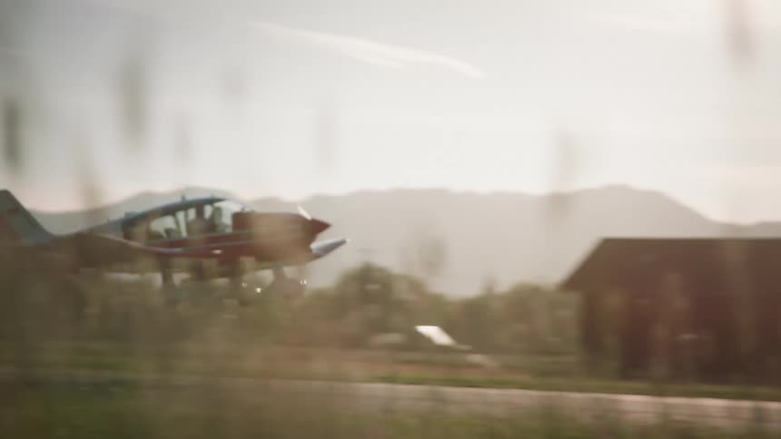 Small red plane taking off
