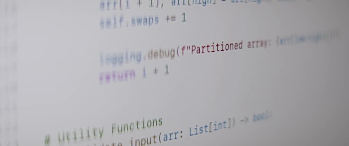 A closeup of a computer screen displays a section of python code with functions scrolling up