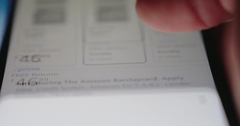 A closeup of a finger hovering pressing a buy now button on a digital screen