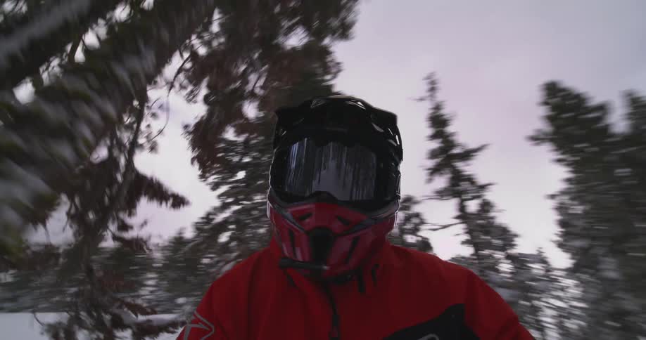 A clip of a person riding through the woods during winter
