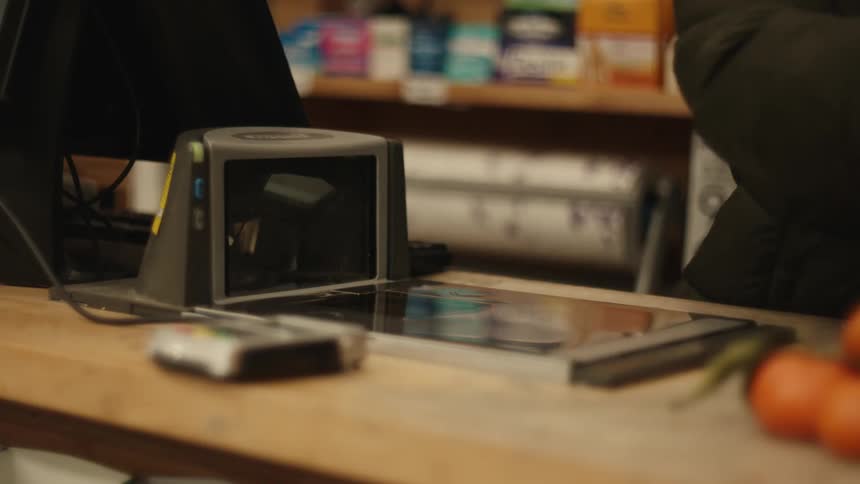 An employee scans items at a grocery store check out counter