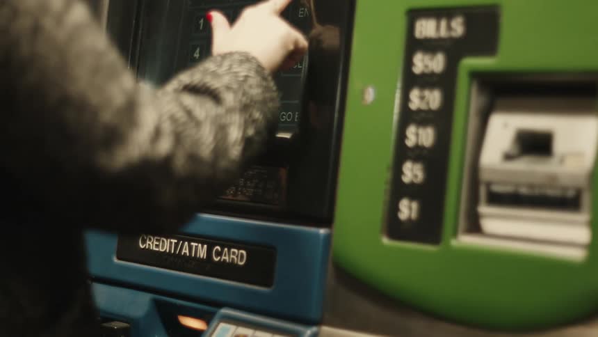 A person is using a ticket vending machine in a subway station