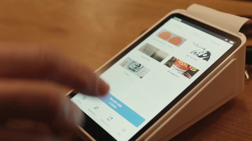 Fingers typing on the screen of a payment machine