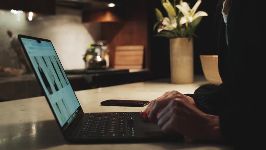 Pair of womans hands using a laptops touch mouse