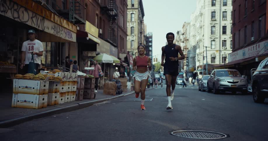Two friends are running on a city road on a commercial street in a city