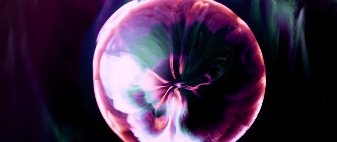 Abstract texture of predominantly pink coloration against a dark background of an expanding vortex