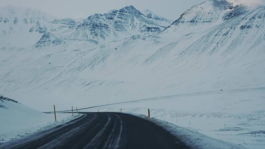 Narrow road surrounded by snow mountains