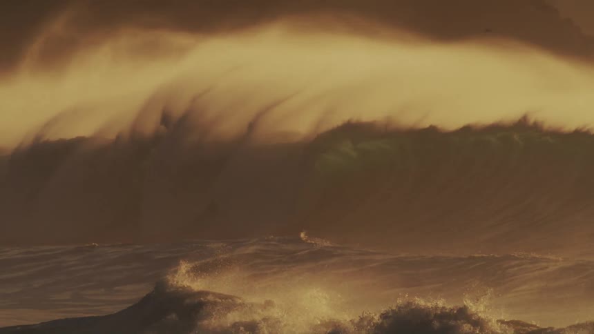 A man is surfing on large waves in the ocean