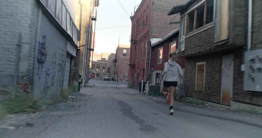 Woman running at high speed through an urban neighborhood