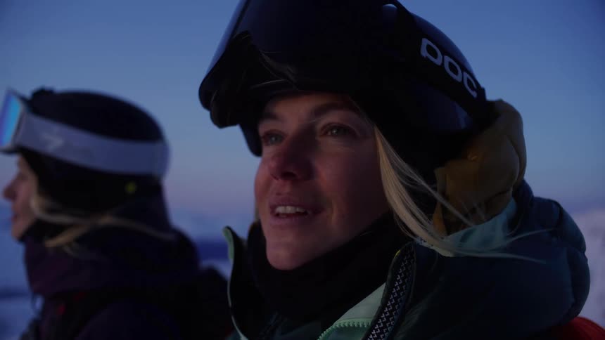Two blonde women with happy facial expression wear winter clothes in snowy mountain environment