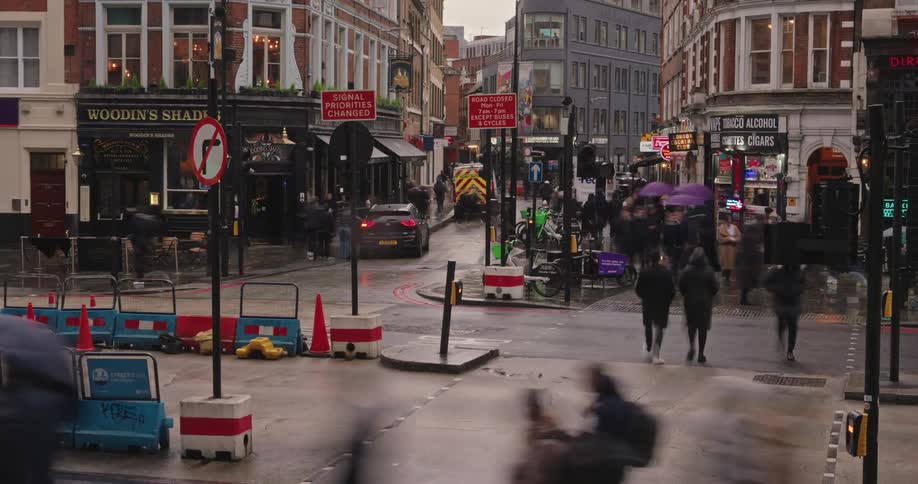 Time lapse of people and vehicles driving around a downtown city block