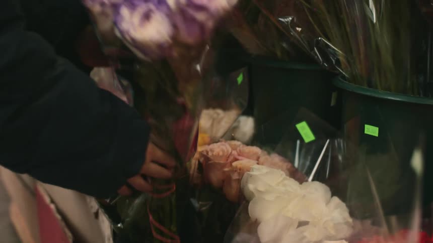 Person picks up a bouquet of roses
