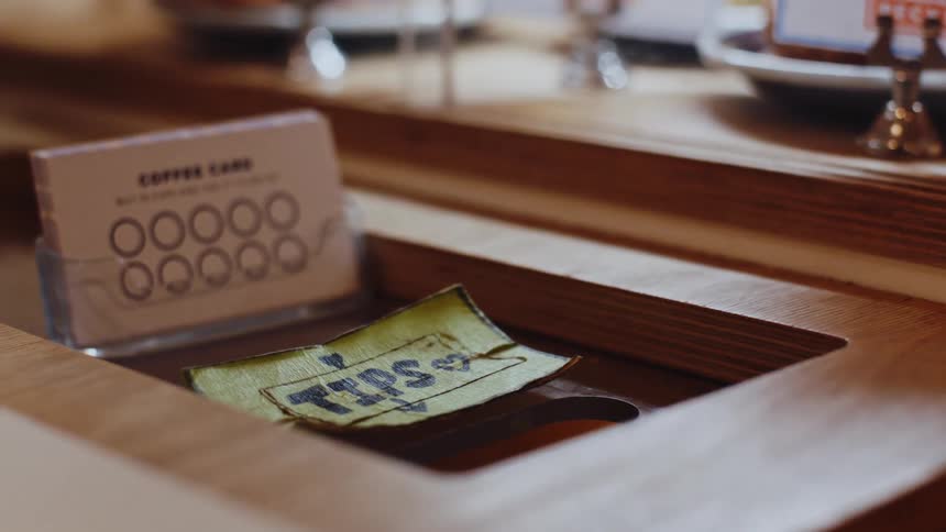 Wooden tip box contains a piece of paper alongside loyalty cards