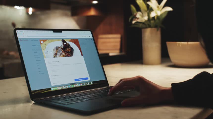 Person uses a laptop at a kitchen table