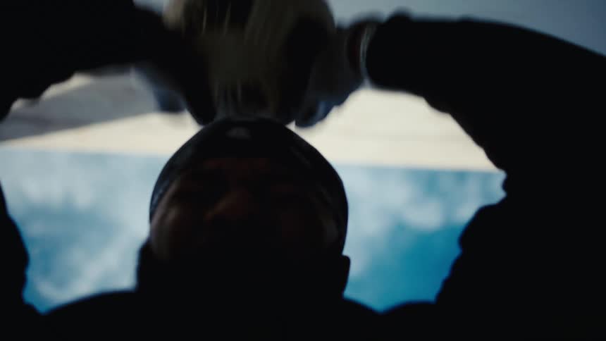 Silhouette of a person with goalkeeper gloves hitting a ball against a wall