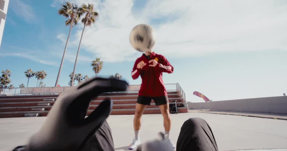 Point of view of a pair of gloved hands repeatedly throwing a ball to another man who is standing