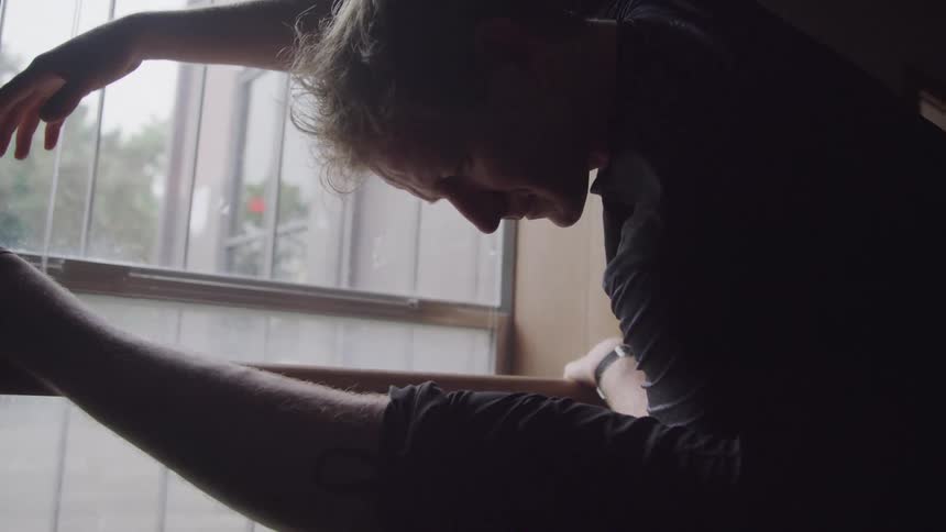 A man is doing yoga by the window