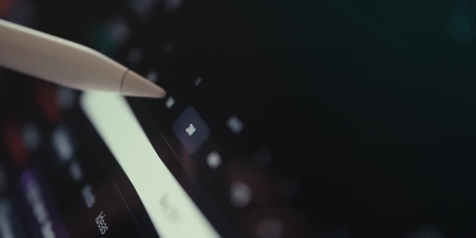 A closeup of stylus interacting with a screen displaying a financial or stock market chart with various colored indicators and numbers