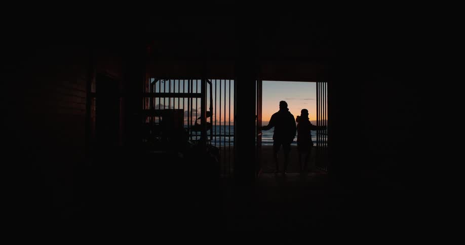 Two people open the gate and walk to the beach