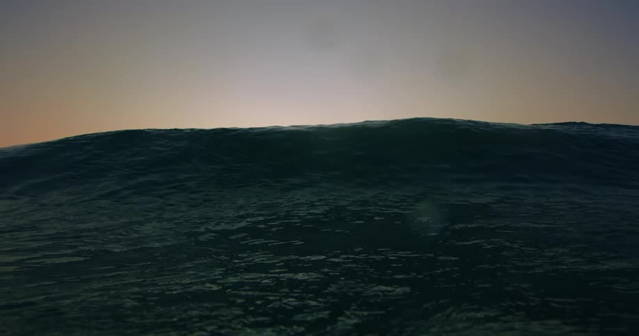 A closeup shot of a dark choppy wave fills the frame under a pale sunset sky