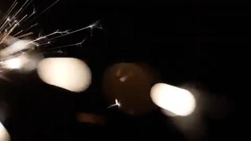 White sparklers continuously light up against a black background
