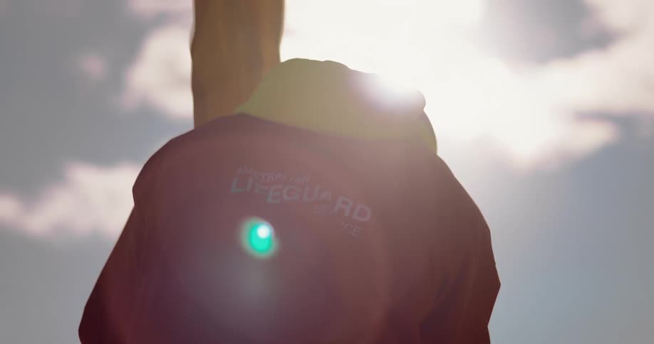 Lifeguard staking down yellow flag at the beach