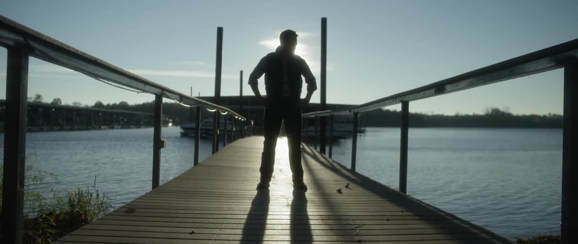 Man standing on a pier on a cloudy day