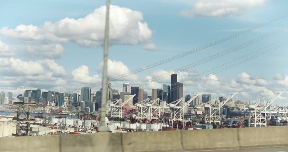 Moving view across a viaduct with a port and a metropolis in the background