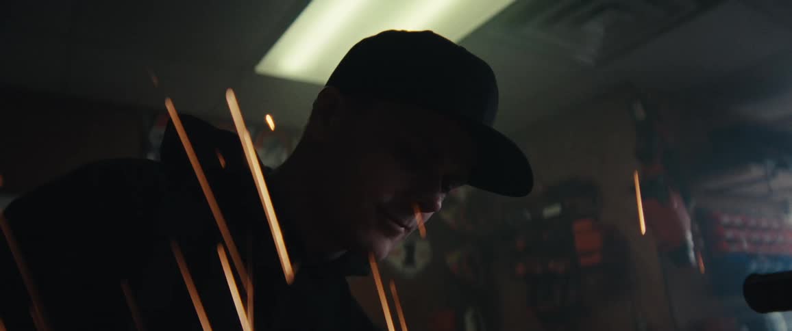 A person wearing a cap is partially visible through streaks of light or sparks