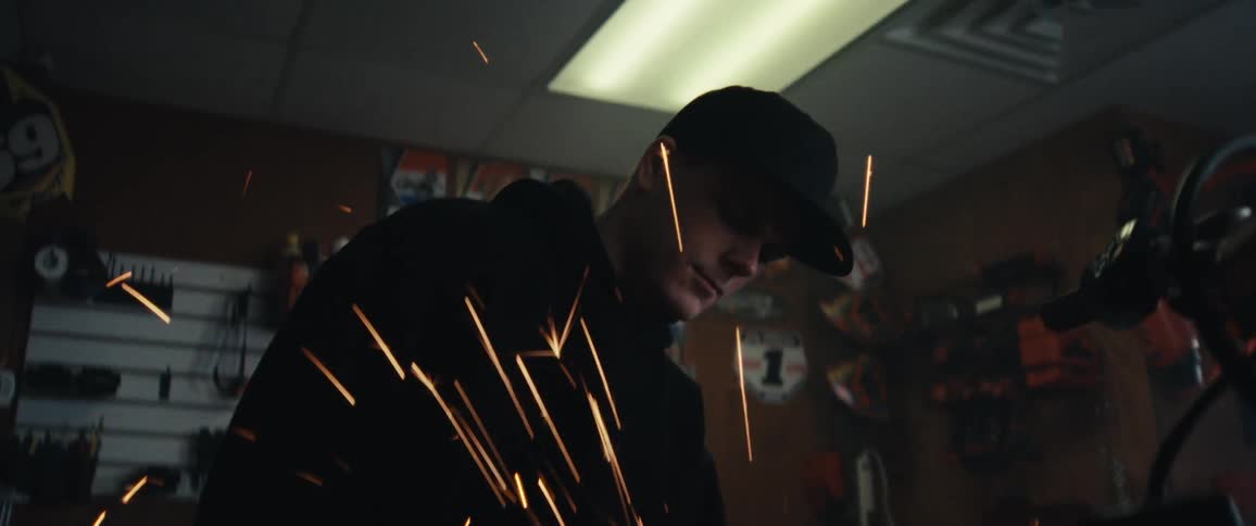 Mechanic using a tool that emits sparks towards a motorcycle