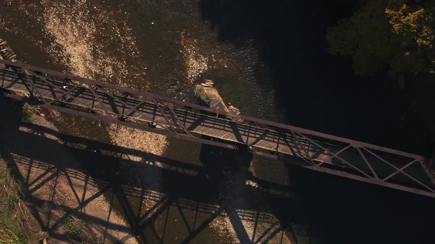 A person crosses the small bridge on a bicycle