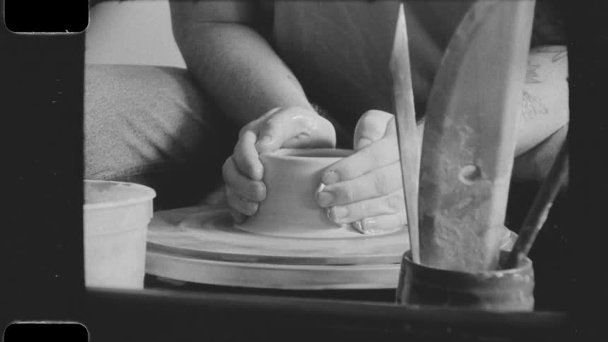 A potter shapes a lump of clay on a spinning wheel