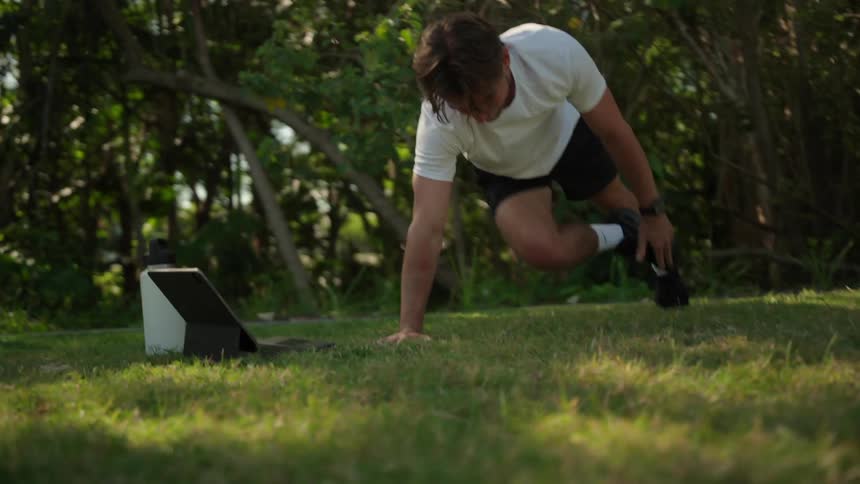 Man exercising in a grassy backyard