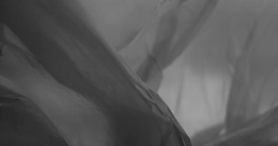 Translucent fabric waves gracefully in the wind against a cloudy sky creating soft flowing folds