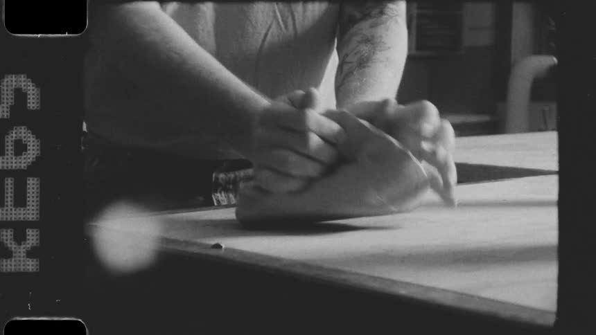 A man is kneading dough on the counter