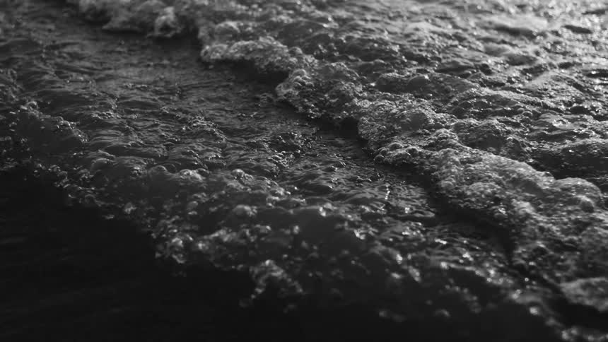 Foamy waves break gently on the beach