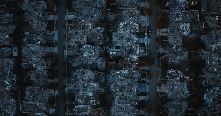 Aerial view shows a suburb burned to the ground after a fire with intersections burned cars houses and trees visible