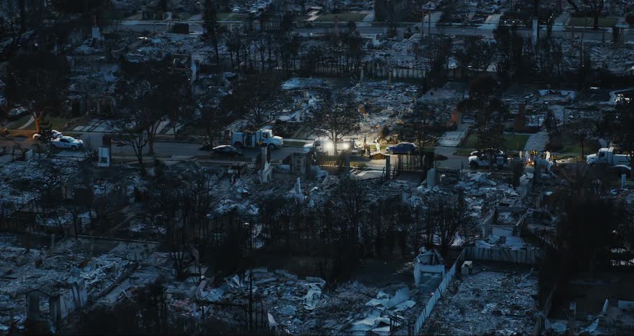 Emergency vehicles are parked on the road where are the homes are demolished