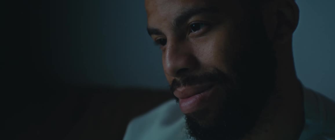 Man smiling and sitting in a room during the night time