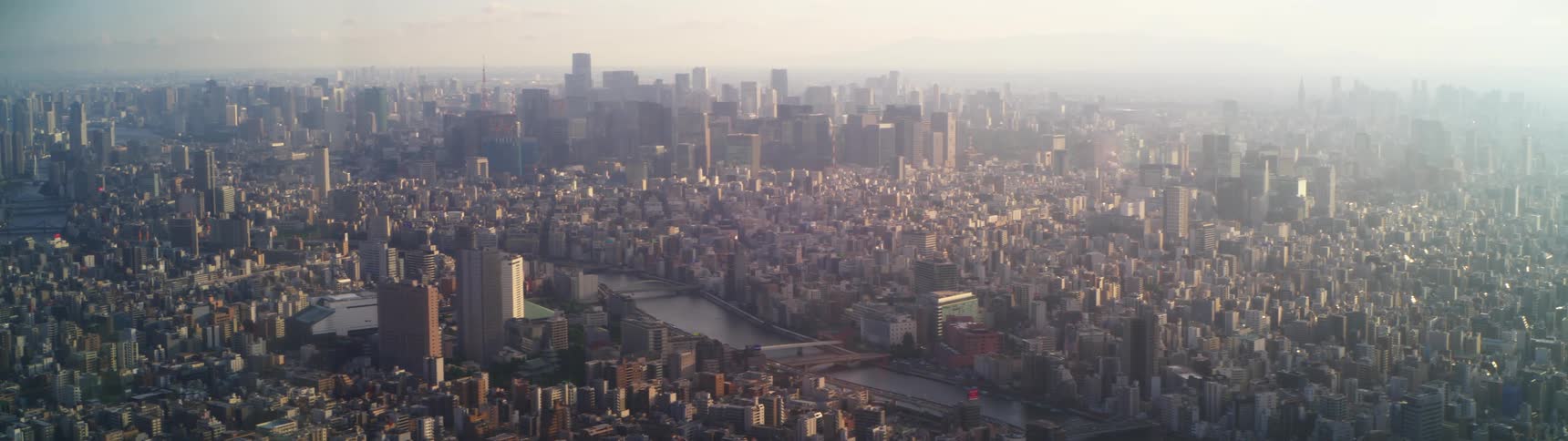 The sun is setting in the horizon above a city with skyscrapers