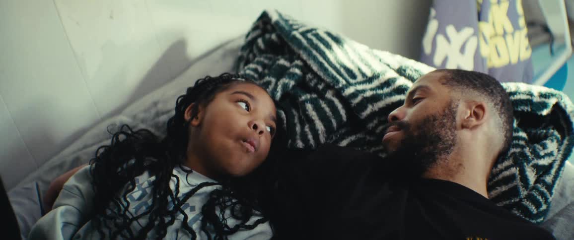 Father lying in bed with his daughter talking