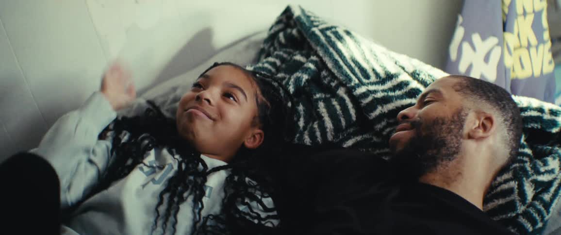 A girl waves her arms and talks with her dad