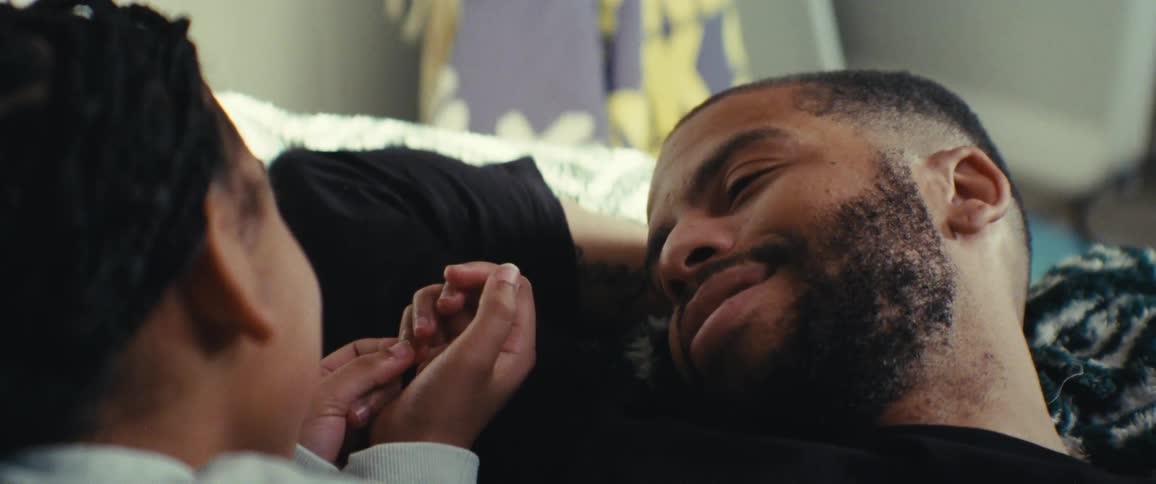 A father and daughter talk while laying down together