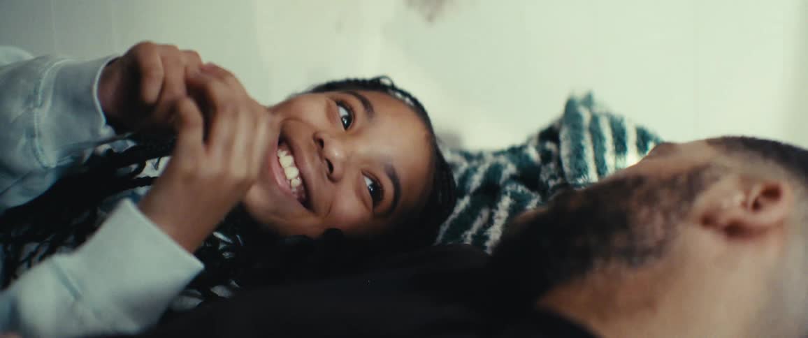 Father lying in bed with his daughter talking