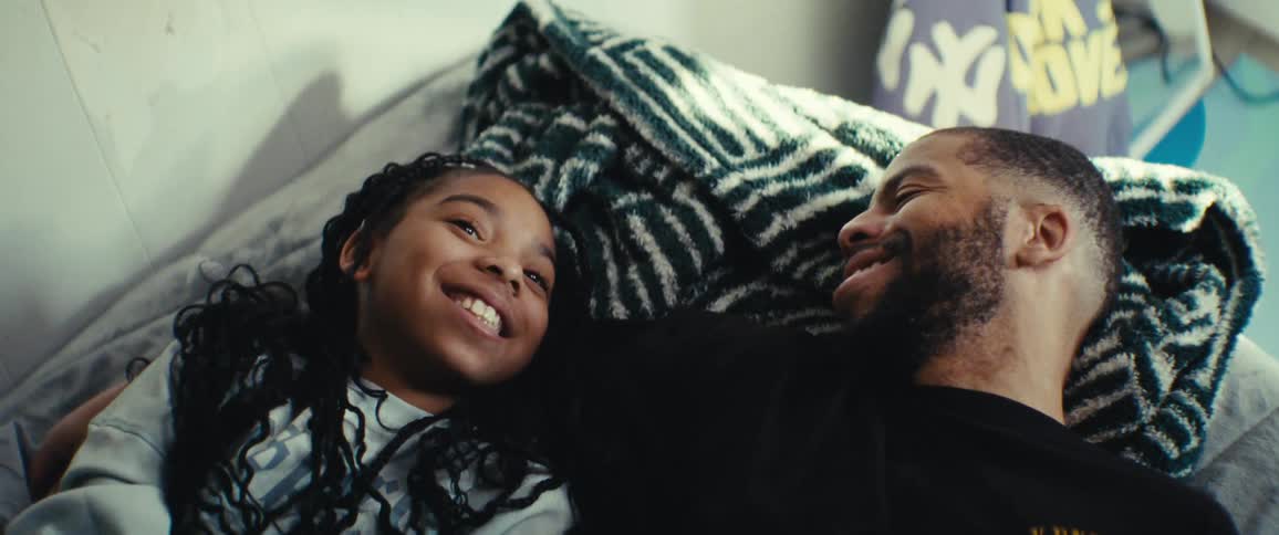 Two young people lying in bed happily